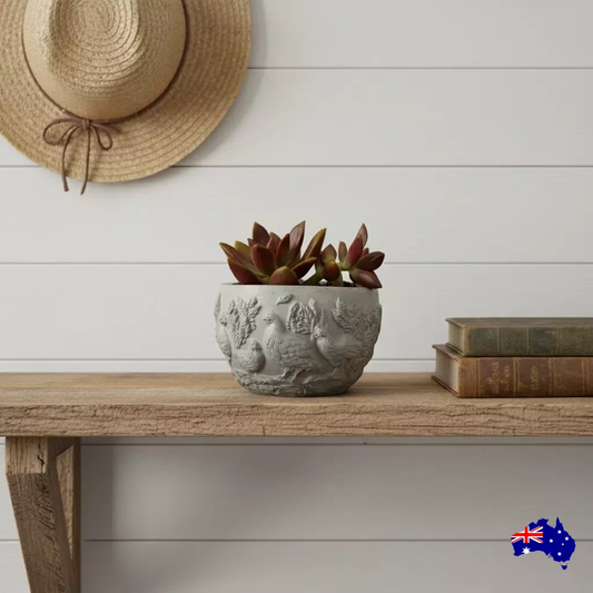 Decorative setting with a potted plant, watering can, and books on a wooden surface.