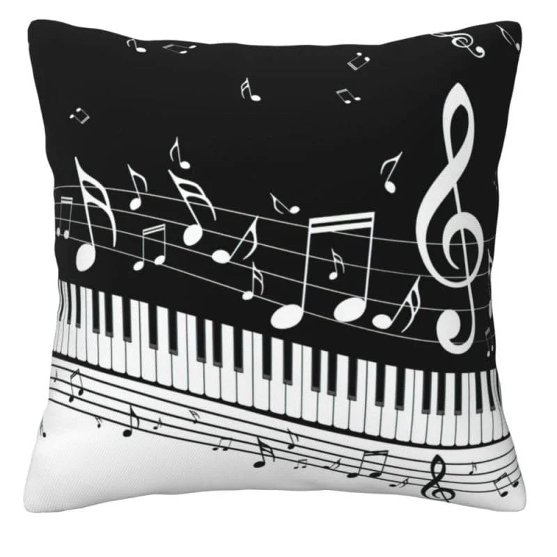 A square decorative throw pillow featuring a black and white musical theme with piano keys, musical notes, and a treble clef.
