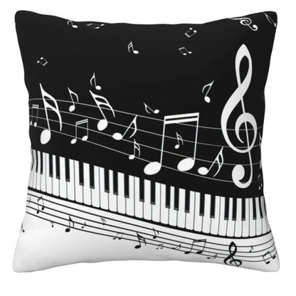 A square decorative throw pillow featuring a black and white musical theme with piano keys, musical notes, and a treble clef.