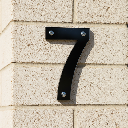 Black acrylic 7 on brick pillar