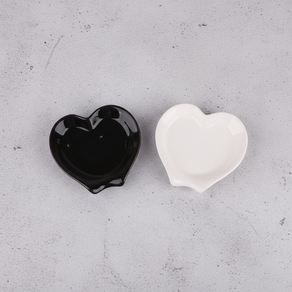 Black and white heart spoon rests on grey concrete