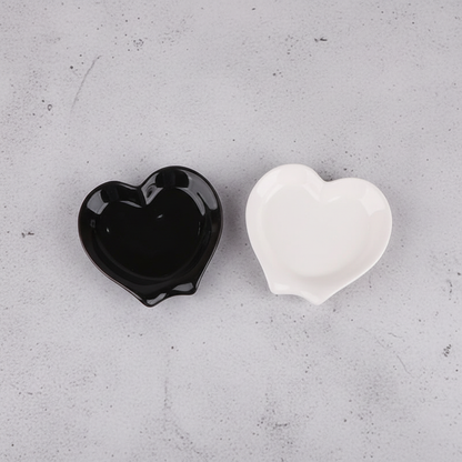 Black and white heart spoon rests on grey concrete