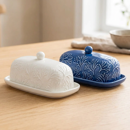 Close-up of the white and blue botanical butter dishes together on a timber table