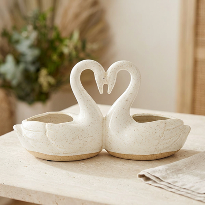 Empty ceramic swan planter on a light stone tabletop