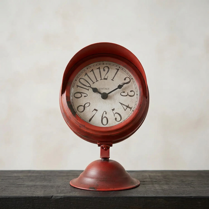 Front-facing clock on a dark timber shelf against pale limewash