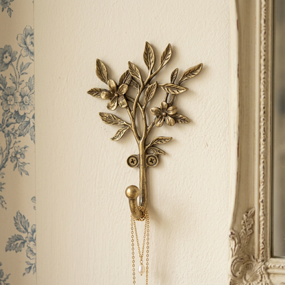 Golden botanical hook holding a necklace in a French provincial bedroom