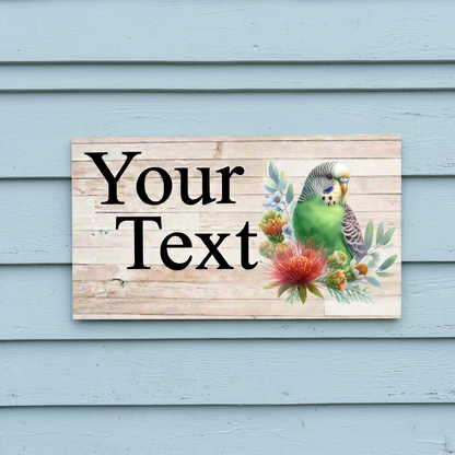 Green budgie sign on blue cottage weatherboards