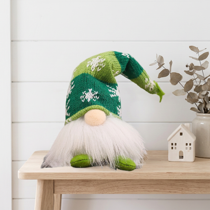 Green snowflake-hat gnome in a coastal Christmas setting