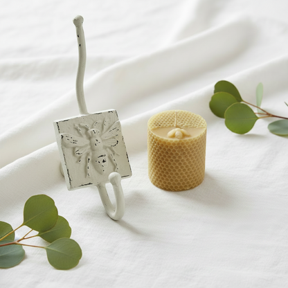 White bee hook and beeswax candle gift set on white linen with eucalyptus and honey dipper — French provincial bee gift Australia