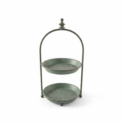 Vintage two-tier metal stand in verdigris green with arched handle and finial on a white background — rustic display tray decor