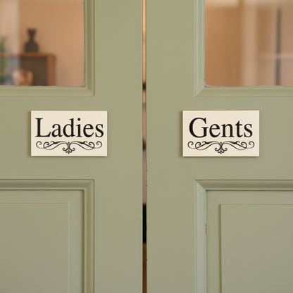 Ladies and Gents White Elegance cream signs on side-by-side cafe doors