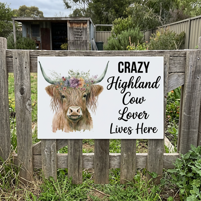Opaque white Highland cow sign on a weathered garden gate