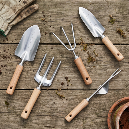 Revised overhead photo of garden tools resting on their sides on a timber table