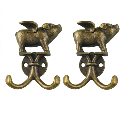Two flying-pig double wall hooks side by side on a white background