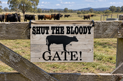Wooden farm gate with cattle in background